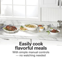Assorted cooked meals in white dishes and bowls on a countertop near utensils.