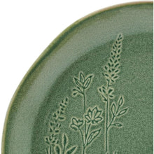 Green stoneware plate detail with raised embossed botanical design