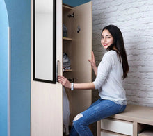 Rectangular over-the-door mirror with black frame held upright by a person