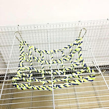 Braided rope climbing net toy laid across a cage platform with metal hooks