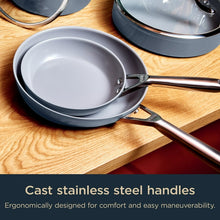 Ceramic non-stick fry pan with cast stainless handle on wooden surface