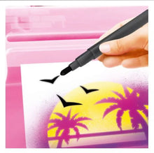 Airbrush tool spraying over a sheet with palm tree stencil and yellow splash