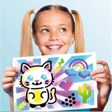 Colorful printed art sheets featuring a cat, rainbow sky, and cactus