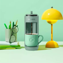 Keurig K-Mini Mate pod coffee maker in Glamping Green with cup on drip tray