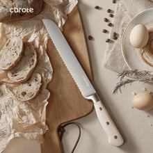 Chef knife with light handle on wooden board beside bread and eggs