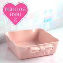 Pink ceramic square baking dish with bow handles, glossy finish
