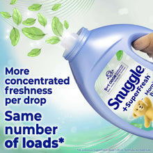 Hand holding Snuggle SuperFresh fabric softener bottle, angled view