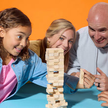Family building a tall tower of light wood Jenga blocks on a tabletop