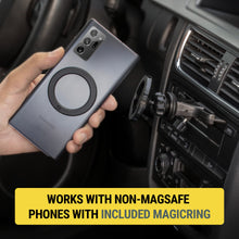 Silver smartphone held by a round magnetic adapter on a black car phone mount