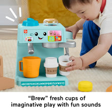 Toddler using teal coffee café toy stand with orange pitcher and white cups
