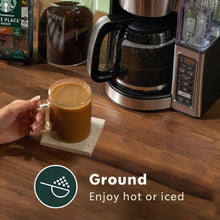 Starbucks Pike Place ground coffee beside a cup of hot brewed coffee