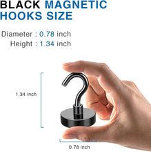 Hand holding a black magnetic hook with curved end and round base