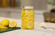 Wide-mouth glass mason jar with metal lid and band, filled with lemon slices