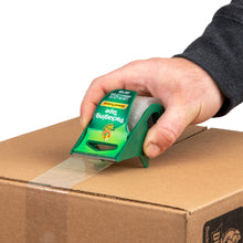 Manual tape dispenser applying clear tape along top seam of a cardboard box
