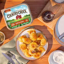 Country Crock Original tub on a table with baked bread pieces on a plate.