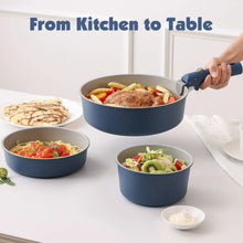Navy ceramic pots and pans with detachable handles, ready for serving on a countertop.
