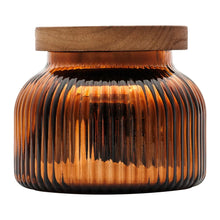 Amber ribbed glass jar candle with wooden lid, top close-up