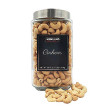 Glass canister of cashews with front label and spilled cashews outside