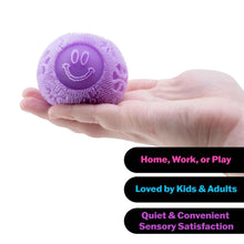 Purple fuzzy flower fidget ball in a hand