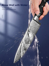Stainless kitchen knife rinsed under water, with water droplets flying