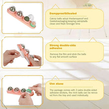 Pink wall-mounted catnip ball toy with three green-brown balls and mounting suction cups.