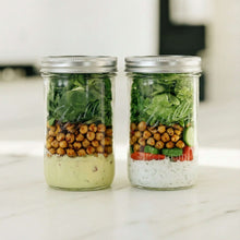 Two Ball wide-mouth mason jars filled with vegetables and herbs