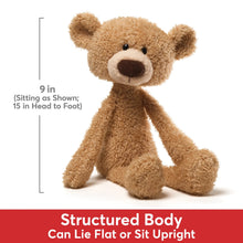 Beige teddy bear plush sitting upright with floppy limbs and round brown nose