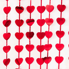 Red foil heart photo backdrop close-up of hanging heart charms