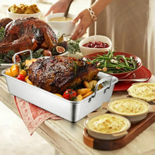 Stainless roasting pan with V-shaped rack and side handles, filled with roasted turkey and vegetables