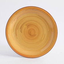 Amber ceramic dinner plate with concentric rings and thin red outer rim
