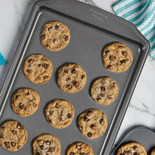 Dark gray baking pan holding several baked cookies