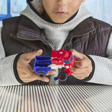 Optimus Prime action figure, red-and-blue parts in hands