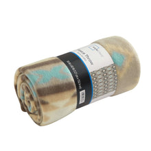 Rolled fleece throw blanket with tan and light blue abstract print, tied with a band.