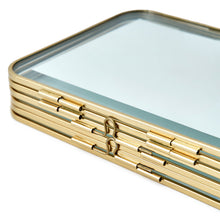 Gold metal folding picture frame close-up of decorative hinge and central emblem