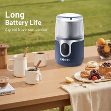 Blue cordless electric coffee grinder on tabletop with clear lid