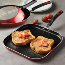 Nonstick griddle pan with black cooking surface, red rim, and two black handles