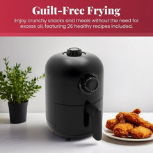 Compact black air fryer, front view with temperature dial and side pull handle.