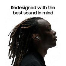 Earbud in ear on person with dreadlocks, small metallic stem visible