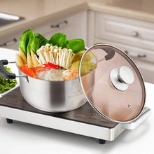 Stainless steel stock pot with glass lid filled with vegetables and pasta