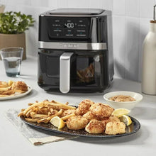 Black digital basket air fryer with front handle and viewing window, with fried food