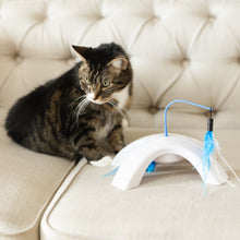 Electronic cat toy with blue wand and fluffy feather swatter on a white curved base