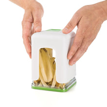 Hands using a white French fry cutter dispensing potato fries into the clear base