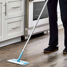 Flat wet and dry mop cleaning hard floors with blue handle and white cloth head