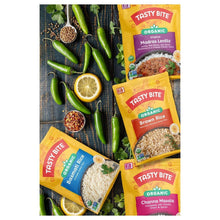 Assorted organic rice pouches with green herbs and citrus on a table