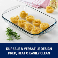 Clear glass baking dish with blue-tinted rim filled with yellow pasta nests