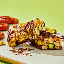 Dark chocolate nut bar pieces with pistachios and pecans, chocolate drizzles
