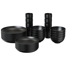 Black wheat-straw dinnerware set with stacked plates, bowls, and tall cups