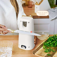 White electric can opener opening a can on a kitchen countertop