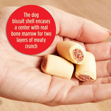 Bone-shaped dog biscuits with brown center shown in open palm