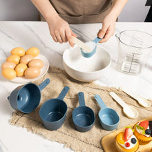 Blue measuring cups and scoops set laid out with measuring pitcher